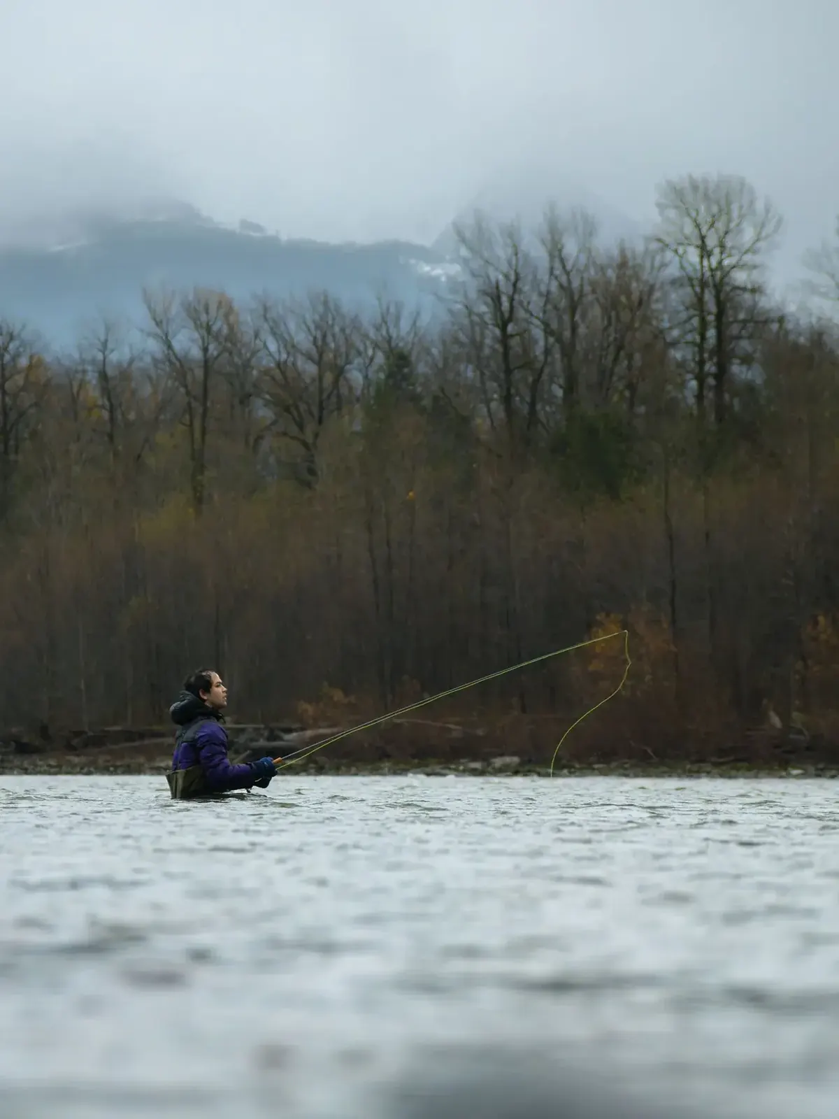 Angler fishing a river in cool conditions